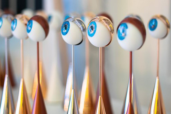 Mehrere Austrian Event Award Trophäen in Form von stilisierten Augen auf glänzenden Metallständern.