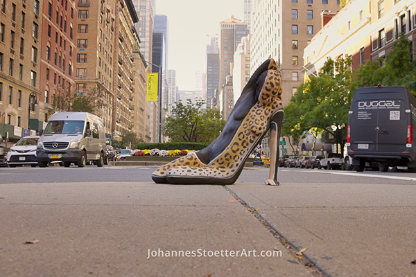 Täuschend echter High Heel mit Leopardenmuster, der in Wirklichkeit ein bemalter Körper ist, mitten auf einer Straße in New York City.