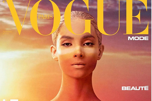 Titelblatt der Vogue Paris mit einem Modell, dessen Gesicht und Körper in warmen Sonnenuntergangsfarben bemalt sind, was den Eindruck von Licht und Schatten verstärkt.