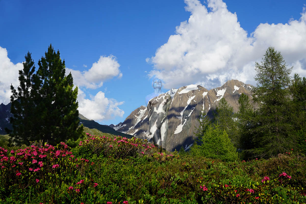 In den Alpen verschmilzt ein bemalter menschlicher Körper durch Bodypainting mit der felsigen Struktur eines Berges, sodass Mensch und Natur wie eins erscheinen.