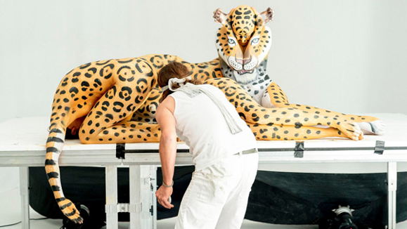 Behind the scenes: the artist works on transforming models into a breathtaking cheetah illusion, where human bodies blend seamlessly into animal form.